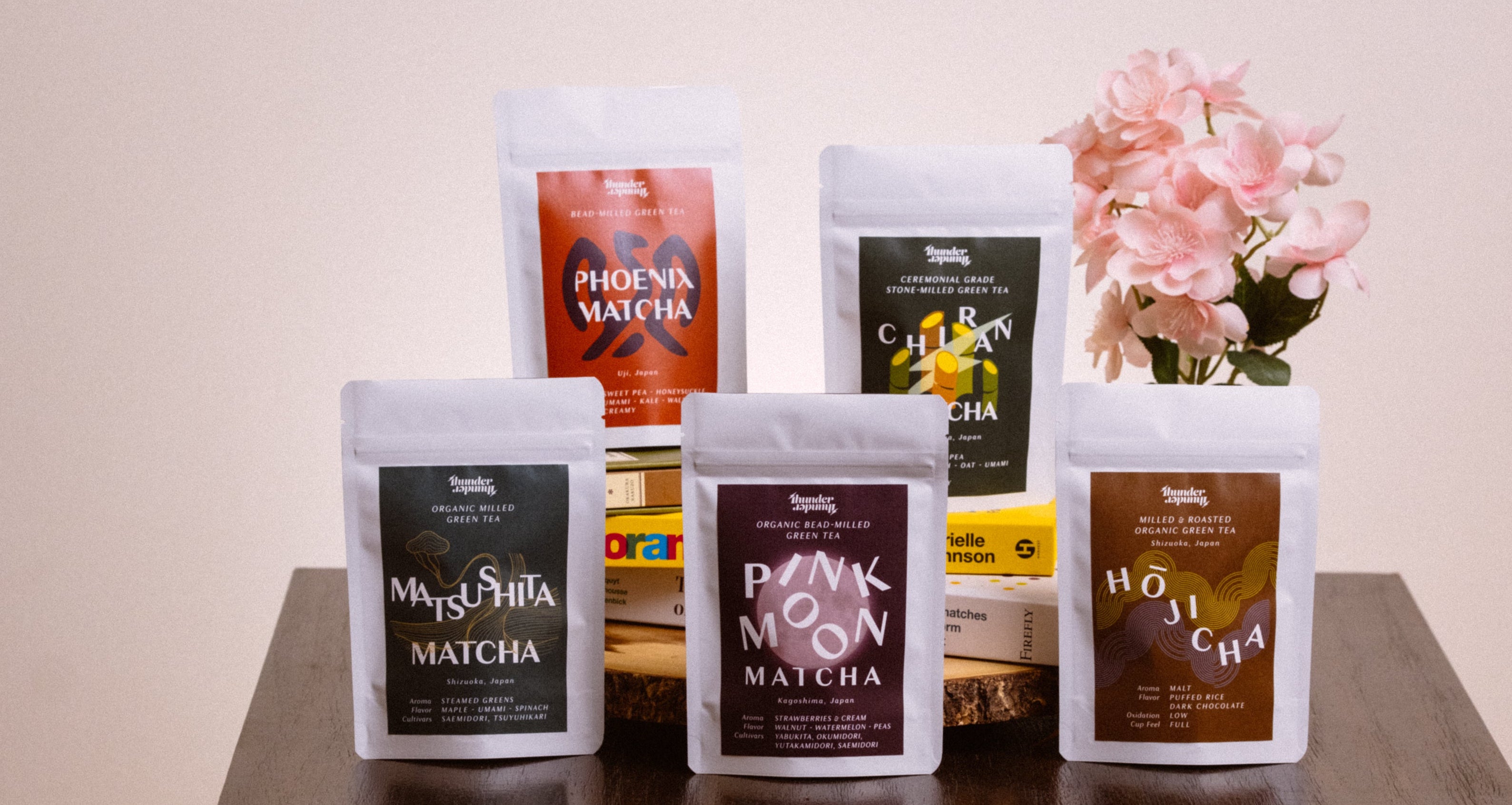 five different types of milled tea ranging from matcha to hojicha arranged to show the spring milled tea sampler with sakura blossoms